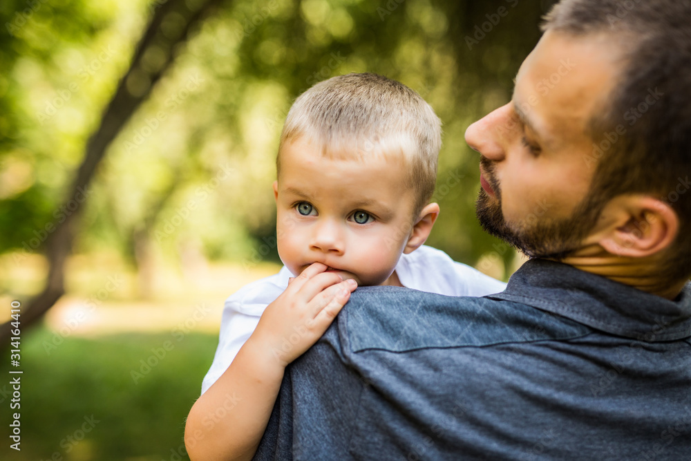 Dad and son having fun in park in summer day. Family.