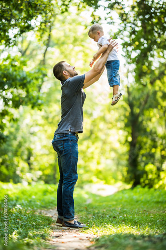 Father and son playing in the park. Concept of friendly family and of summer vacation.