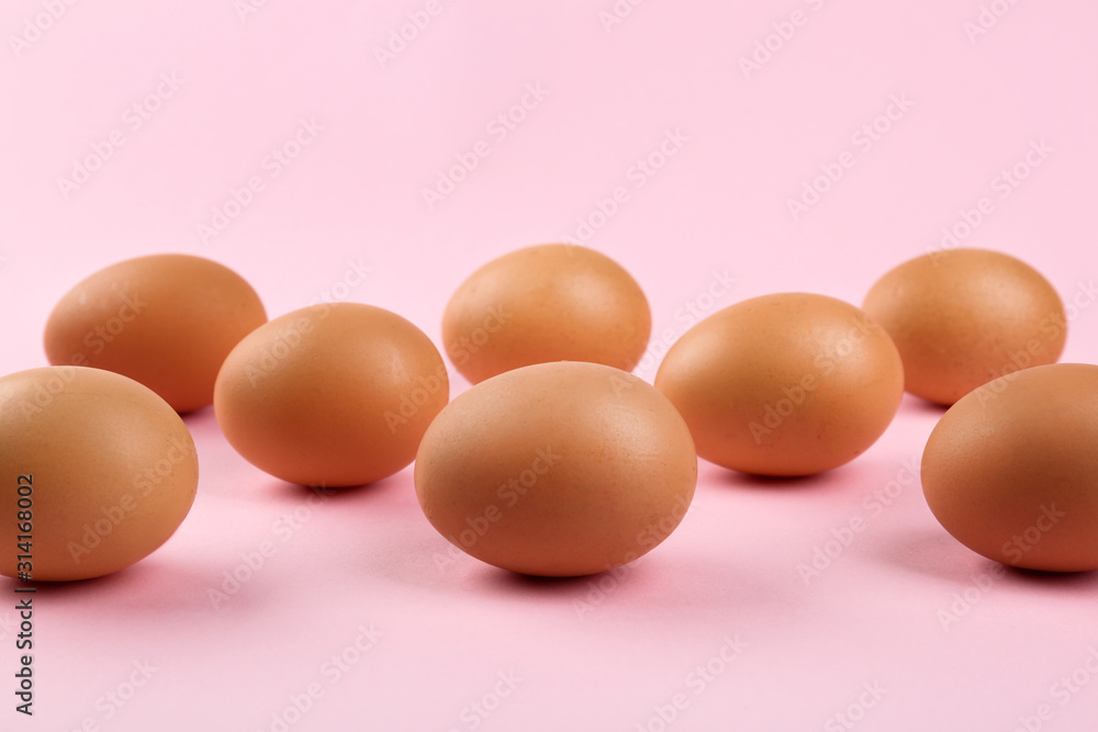 Raw brown chicken eggs on pink background Raw brown chicken eggs on pink background