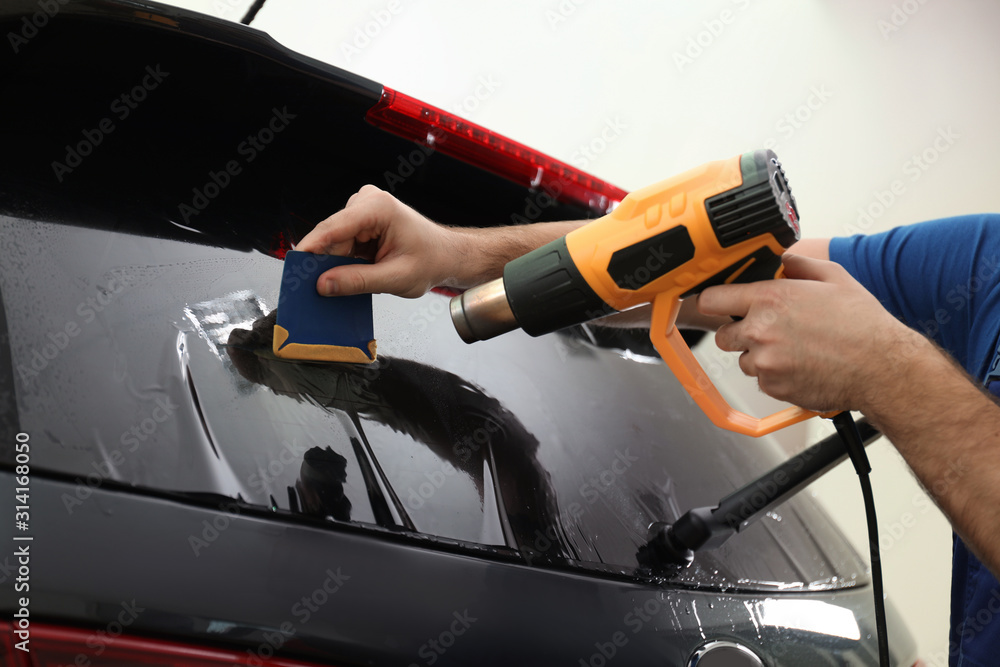 Worker tinting car window with heat gun in workshop, closeup Stock ...