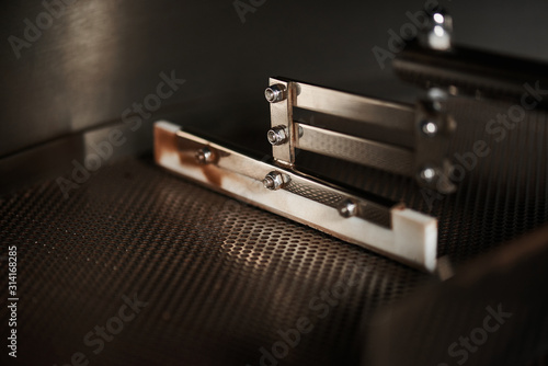 Technology and equipment for processing coffee. Steel part of a professional coffee roasting machine. Close-up.