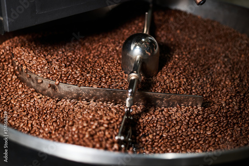 Coffee beans are well roasted on coffee roasting equipment. Close-up.