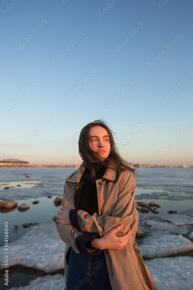 Portrait of beautiful young woman. Photo shoot series near river at winter.