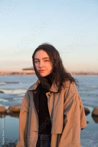 Portrait of beautiful young woman. Plein air photo shoot series near river at winter.