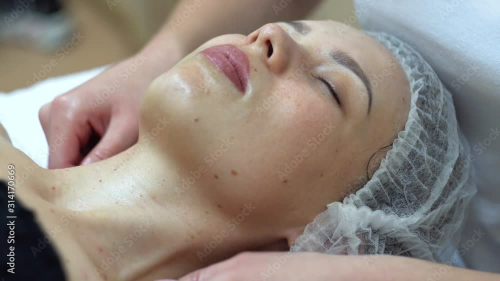 Massage therapist is doing manual massage on client's face. Spa facial massage Massage therapist is doing manual massage on client's face. Spa facial massage
