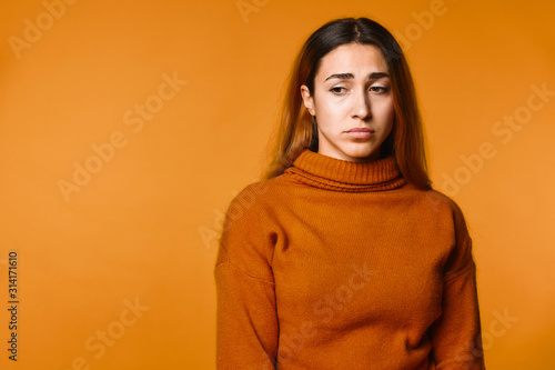 Foto Upset young attractive caucasian girl dressed in pullover  of ocher colour  on t