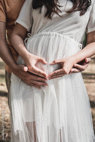 Pregnant woman and Husband  posing outdoors. © dekliyngkaea