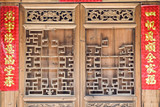 The old traditional style wood carving door with Spring festival couplets during Chinese new year.The text on scrolls means Everything goes well and Good Fortune for the whole Family.