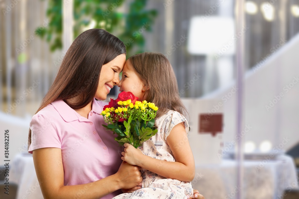 Mother and daughter with bouquet of flowers on blurred background. Mother and daughter with bouquet of flowers on blurred background.