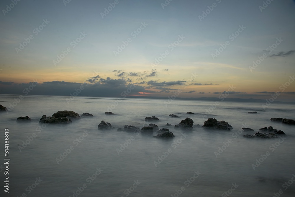 Landscape image Foggy sea sunset with stones