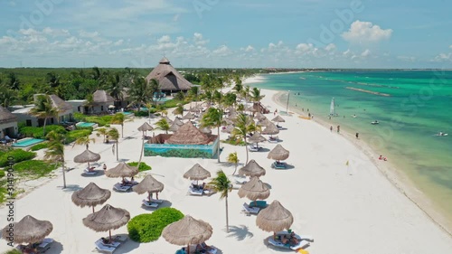 Aerial Drone Shot Over Beautiful Playa Del Carmen, Quintana Roo - Mexico.
Flying Low Over White Sandy Beach With Straw Beach Umbrellas and Turquoise Blue Sea. photo