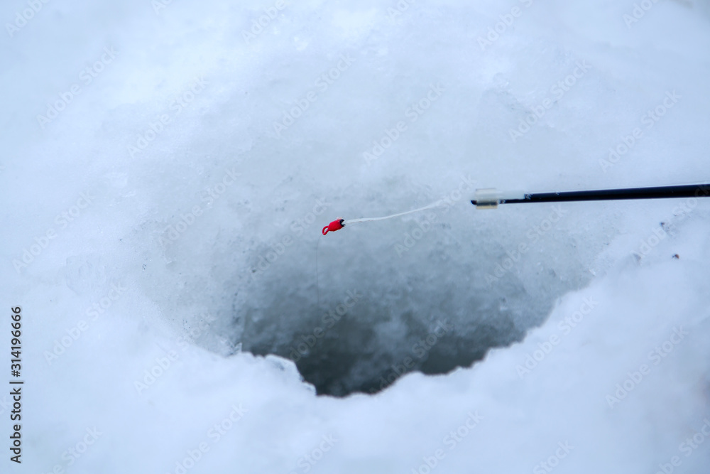 the nod of the winter fishing rod over the hole