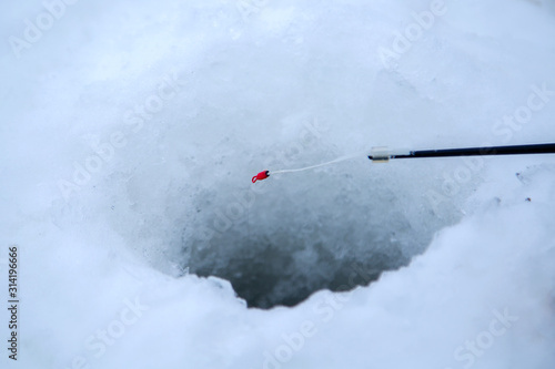 Fotografie the nod of the winter fishing rod over the hole