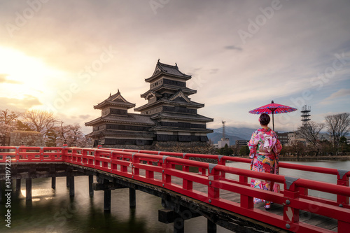 Fotografie Young asian woman wearing Kimono Japanese tradition dressed sightseeing at Matsumoto Castle during cherry blossom (Sakura) is one of the most famous sights in Matsumoto, Nagano, Japan