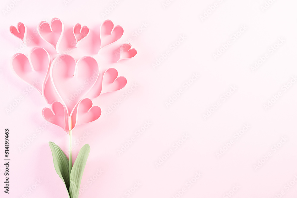 Pink paper hearts in shape of flower on Light pink pastel paper background. Love and Valentine's day concept.