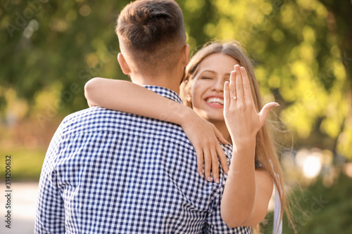 Happy engaged couple hugging outdoors
