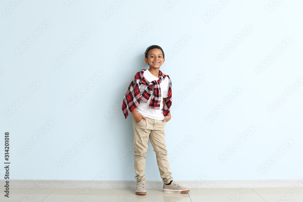 Fototapeta premium Cute fashionable African-American boy on color background