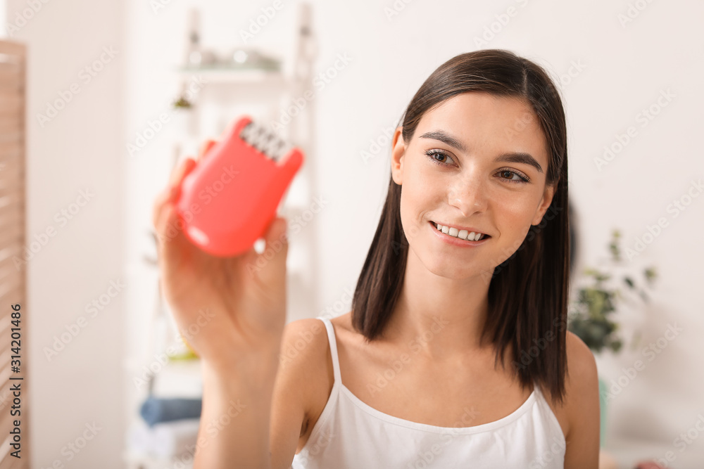 Beautiful young woman with modern epilator in bathroom Beautiful young woman with modern epilator in bathroom