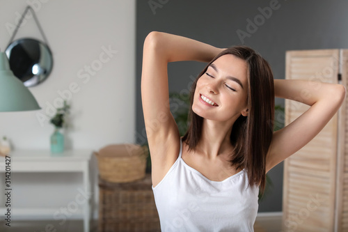 Beautiful young woman after depilation of armpits in bathroom photo