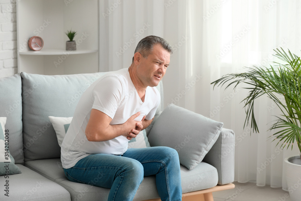 Mature man suffering from heart attack at home Mature man suffering from heart attack at home