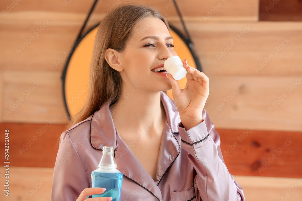 Ταπετσαρία Beautiful young woman with mouth rinse in bathroom
