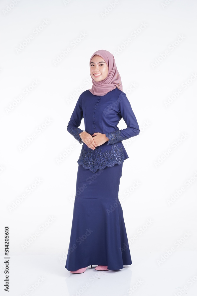 A beautiful Muslim female model wearing a dark blue modern kebaya with hijab, an Asian Muslim traditional dress isolated on white background. Eidul fitri fashion and lifestyle portrait concept.