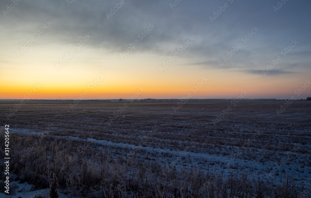 Winter frosty sunrise in the open area above the snowy surface of agricultural fields. Winter frosty sunrise in the open area above the snowy surface of agricultural fields.