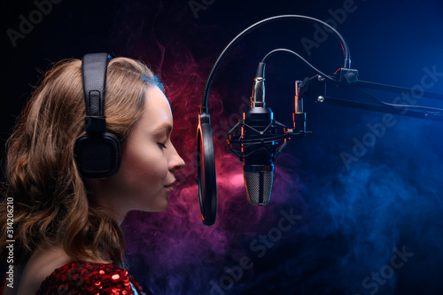 Vocal teacher singing with a studio microphone in a studio with a bright background. Teaching vocals and solo singing. Soundtrack and album recording photo