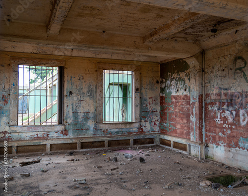 Abandoned prison jail building complex with graffiti and broken foundation