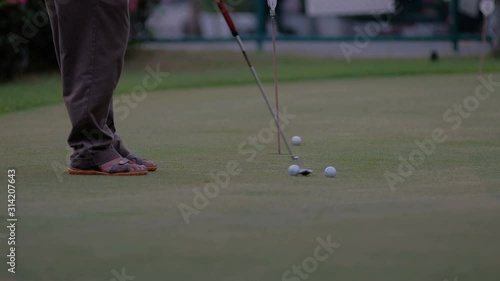 golfer putting golf ball in to the hole