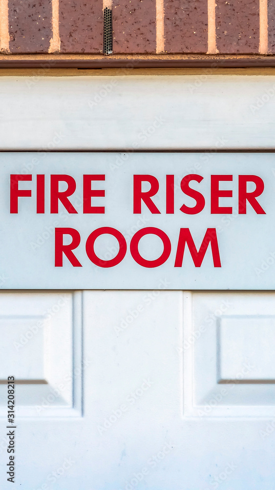 Vertical frame Close up of the Fire Riser Room with white wooden door of a brick building