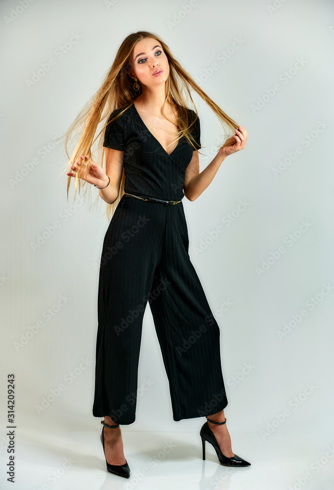 Model student manager stands in different poses in front of the camera in the studio. Full-length portrait of a pretty blonde girl with long hair and excellent make-up on a white background. Model student manager stands in different poses in front of the camera in the studio. Full-length portrait of a pretty blonde girl with long hair and excellent make-up on a white background.
