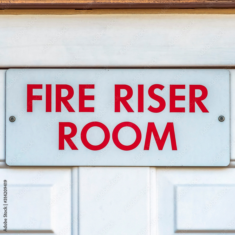 Naklejka premium Square Close up of the Fire Riser Room with white wooden door of a brick building