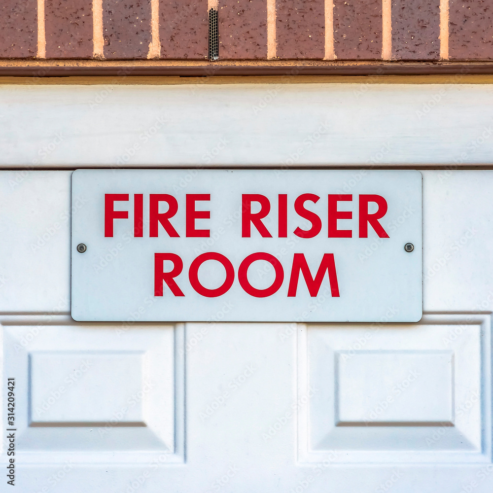 Square frame Close up of the Fire Riser Room with white wooden door of a brick building