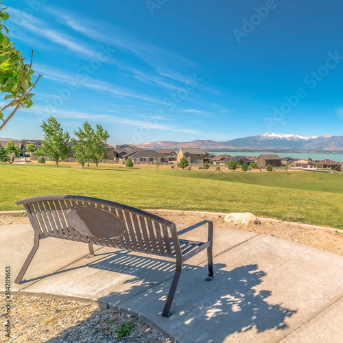 Square frame Park metal bench with view of lake snowy timpanogos mountains and blue sky
