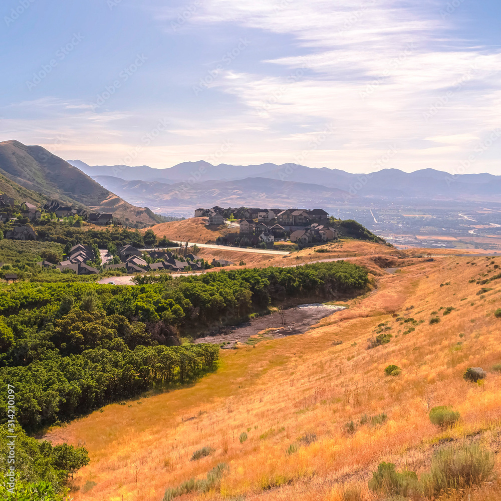 Fototapeta premium Square Scenic mountain landscape with houses amidst vast slopes covered with greenery