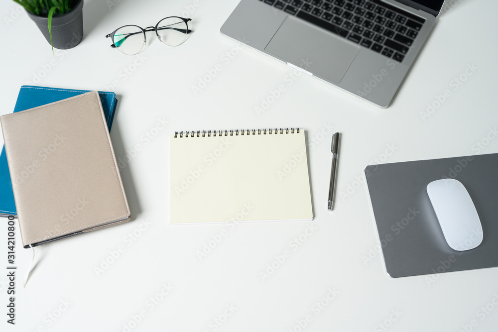 Modern white office desk table with laptop computer and empty notebook. Top view with copy space, flat lay. Modern white office desk table with laptop computer and empty notebook. Top view with copy space, flat lay.