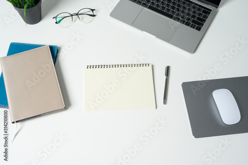 Wallpaper Mural Modern white office desk table with laptop computer and empty notebook. Top view with copy space, flat lay. Torontodigital.ca