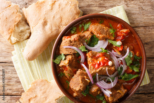 Chashushuli is a traditional Georgian beef stew with tomato sauce close-up in a bowl. Horizontal top view photo