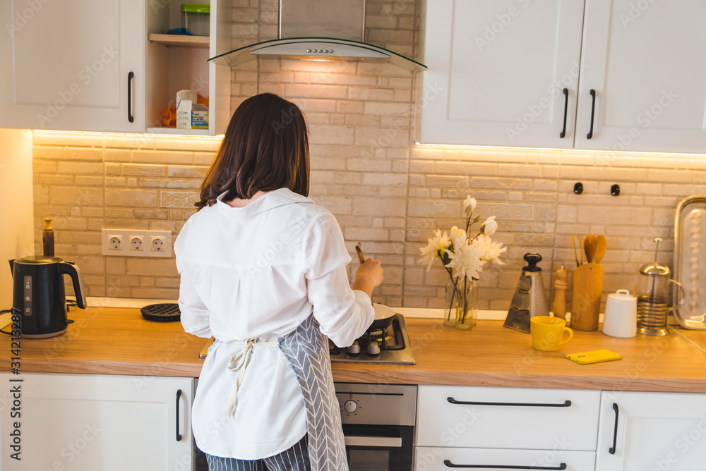 view from behind woman on kitchen cooking view from behind woman on kitchen cooking