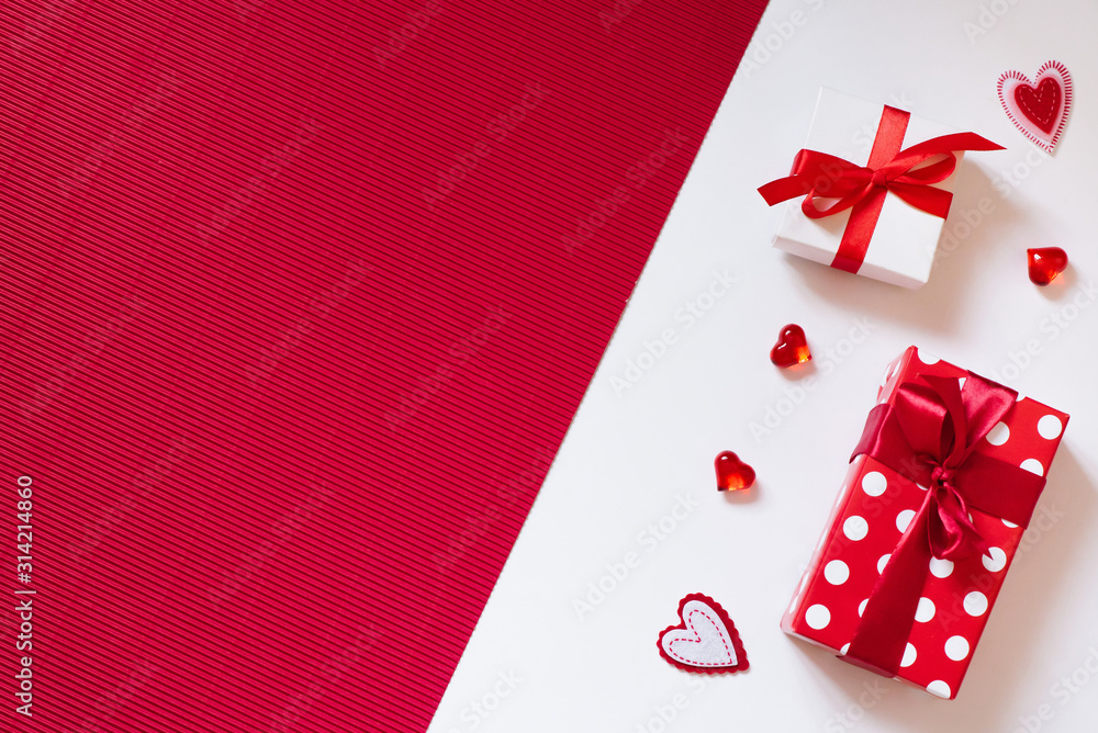 Gift boxes with bows and hearts on a red and white background. Creative thinking about love and Valentine's Day Gift boxes with bows and hearts on a red and white background. Creative thinking about love and Valentine's Day