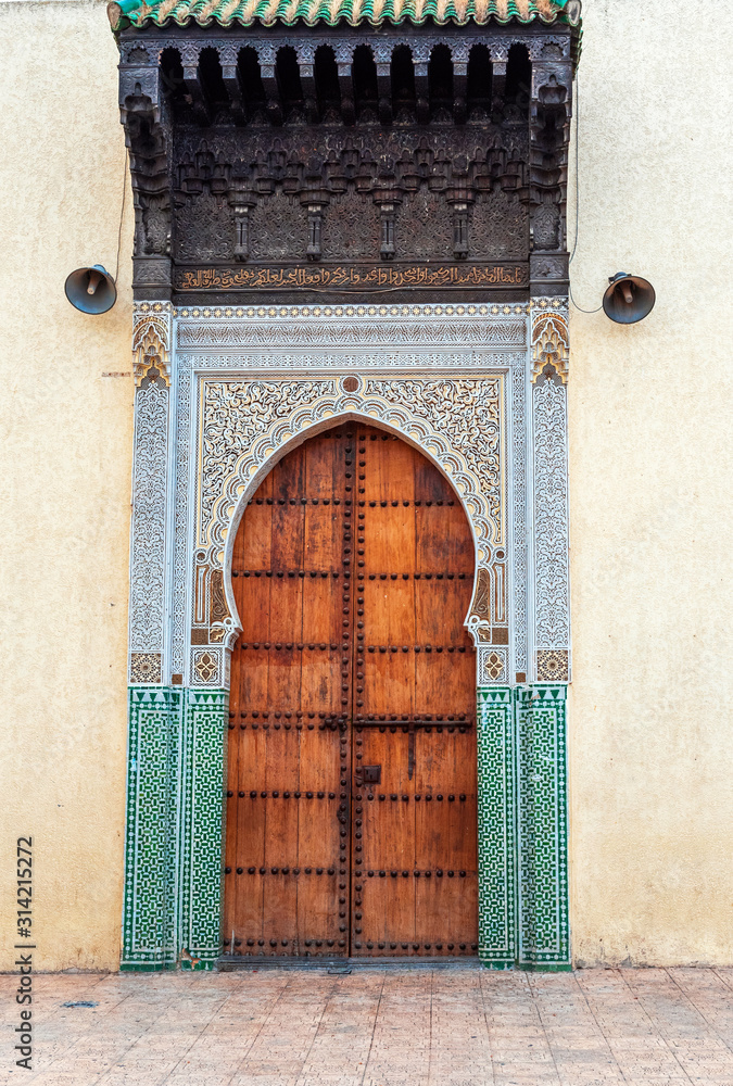Naklejka premium Wooden door in oriental style, Fez, Morocco. Vertical.