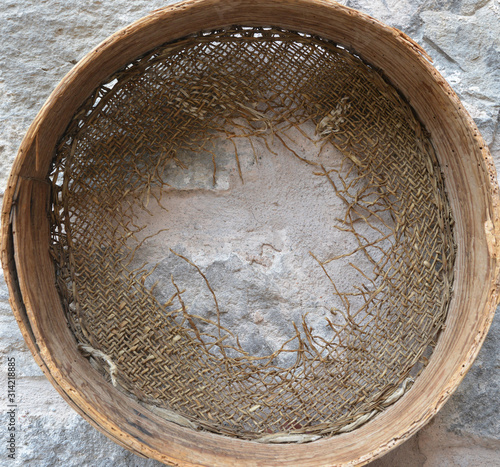 old sieve on stone wall background