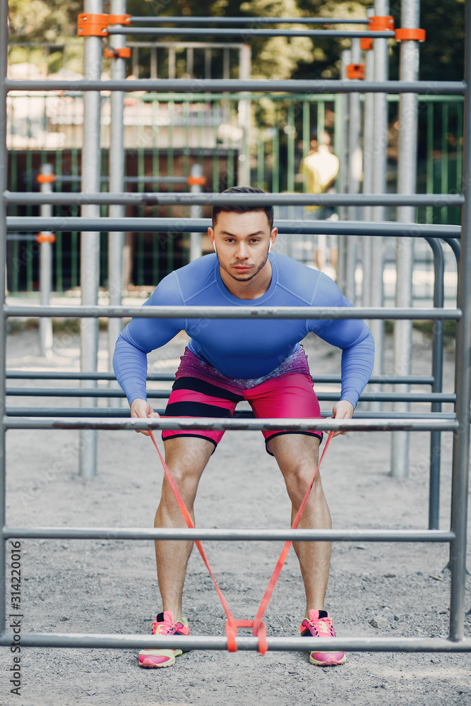 Man training. Guy in a sports clothes. Male in a summer park