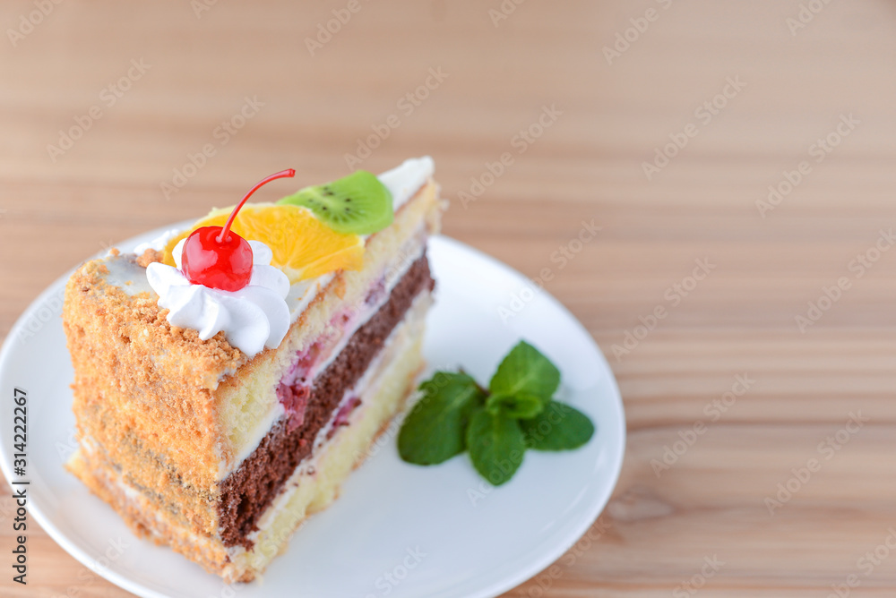 Sweet summer fruit cake with slices of orange, kiwi, cherries. frosting and whipped cream on top Sweet summer fruit cake with slices of orange, kiwi, cherries. frosting and whipped cream on top