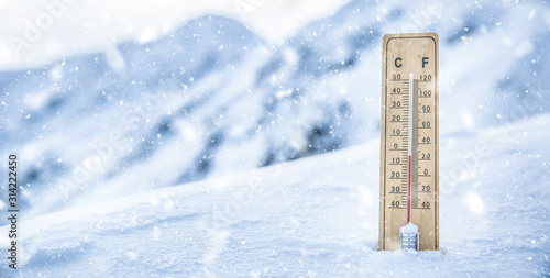 Thermometer on the mountains in the snow shows temperatures below zero. Low temperatures in degrees Celsius and fahrenheit in snowy weather