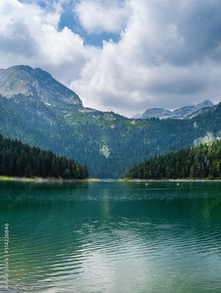 Black lake (Crno jezero) summer landscape. Zabljak Municipality, Montenegro. People unrecognizable. Black lake (Crno jezero) summer landscape. Zabljak Municipality, Montenegro. People unrecognizable.