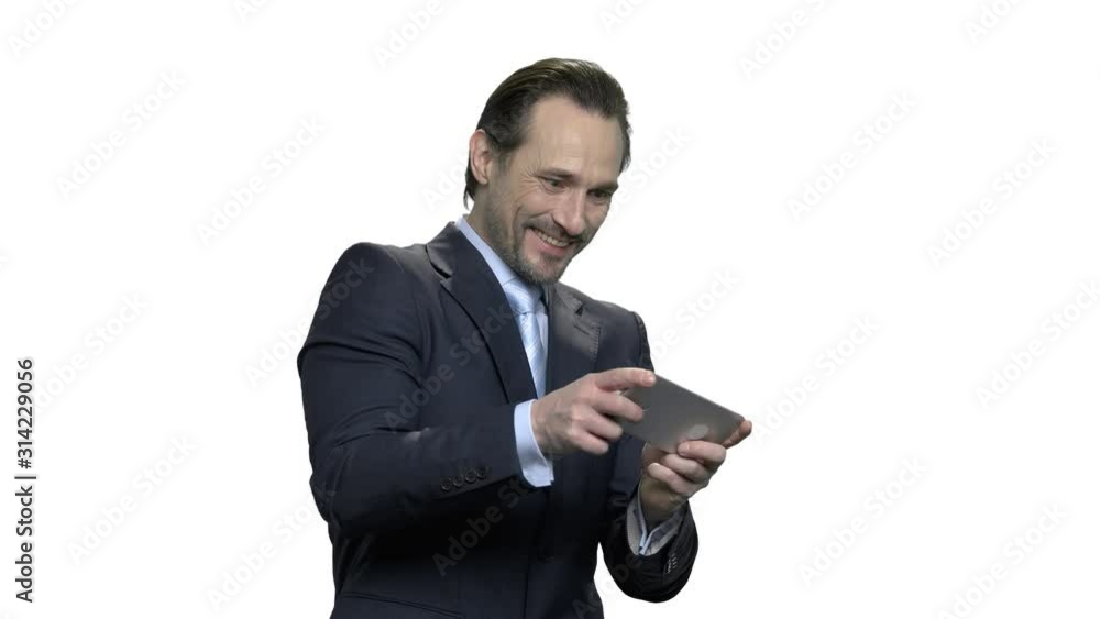 Concentrated mature business man plays game on smartphone. Excited caucasian manager playing video game on mobile phone. Isolated on white background. Concentrated mature business man plays game on smartphone. Excited caucasian manager playing video game on mobile phone. Isolated on white background.