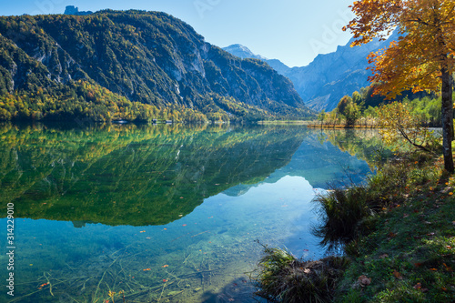 Peaceful autumn Alps mountain lake with clear transparent water and reflections. Almsee lake, Upper Austria.