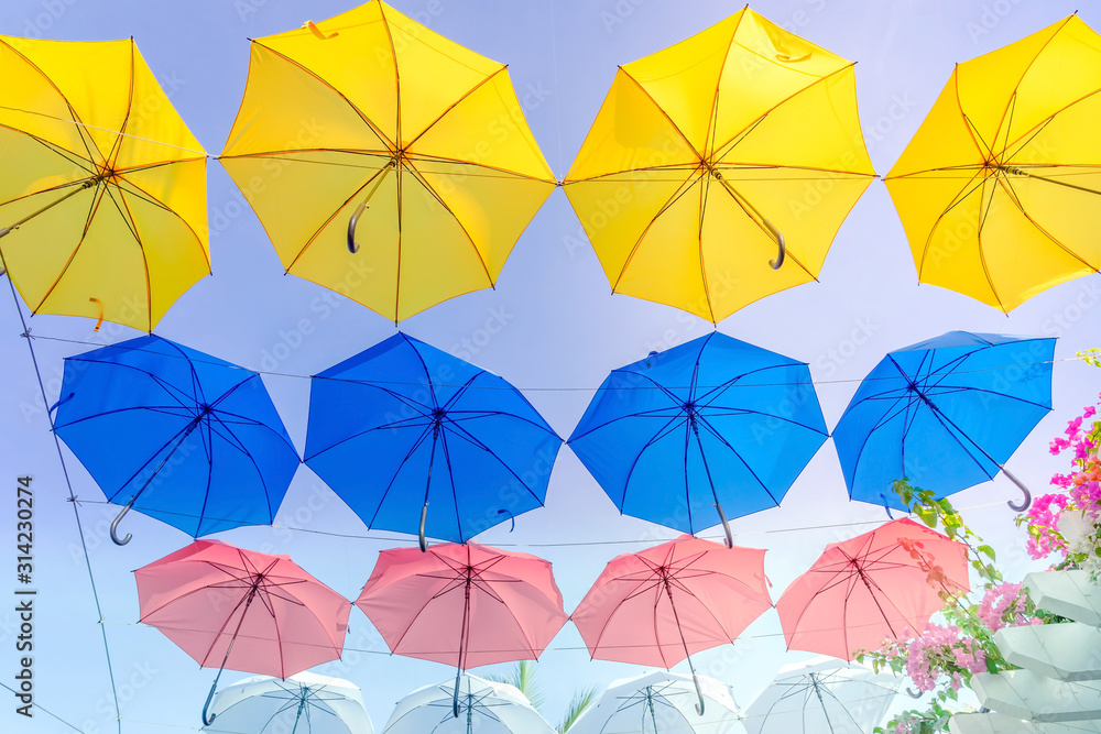 Street decorated with colorful umbrellas hanging on top side in the sky. Colorful umbrellas background.